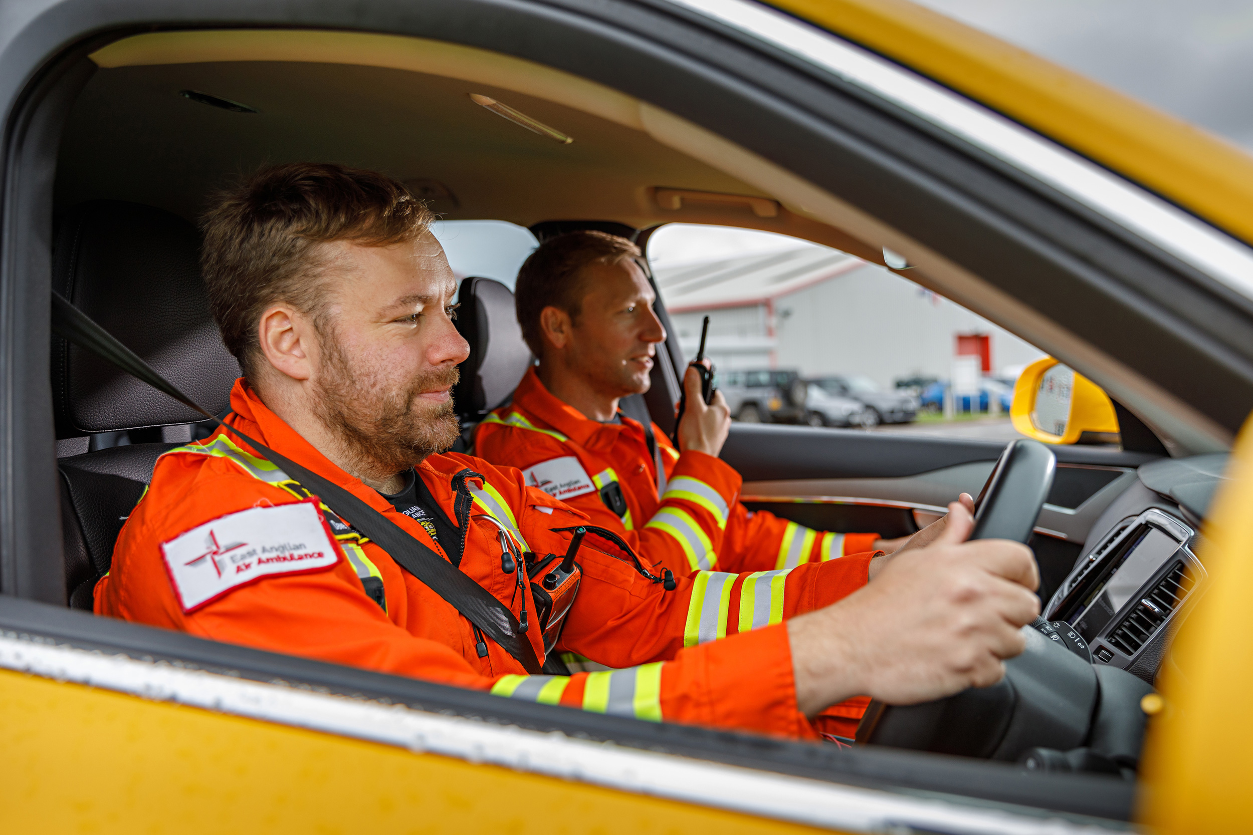 Doctor and paramedic in critical care car on radio