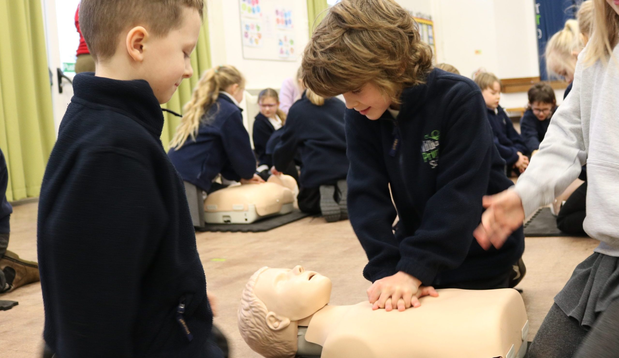 School children learning how to do CPR