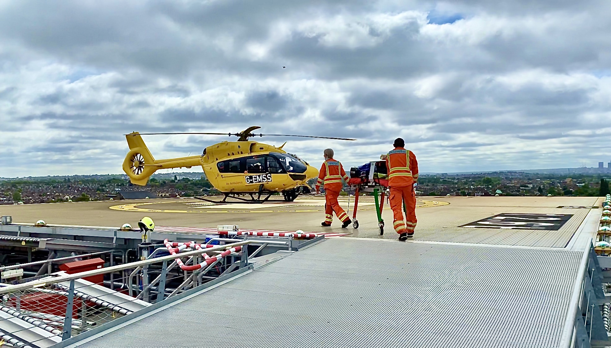 crew pushing trolley to helicopter on helipad