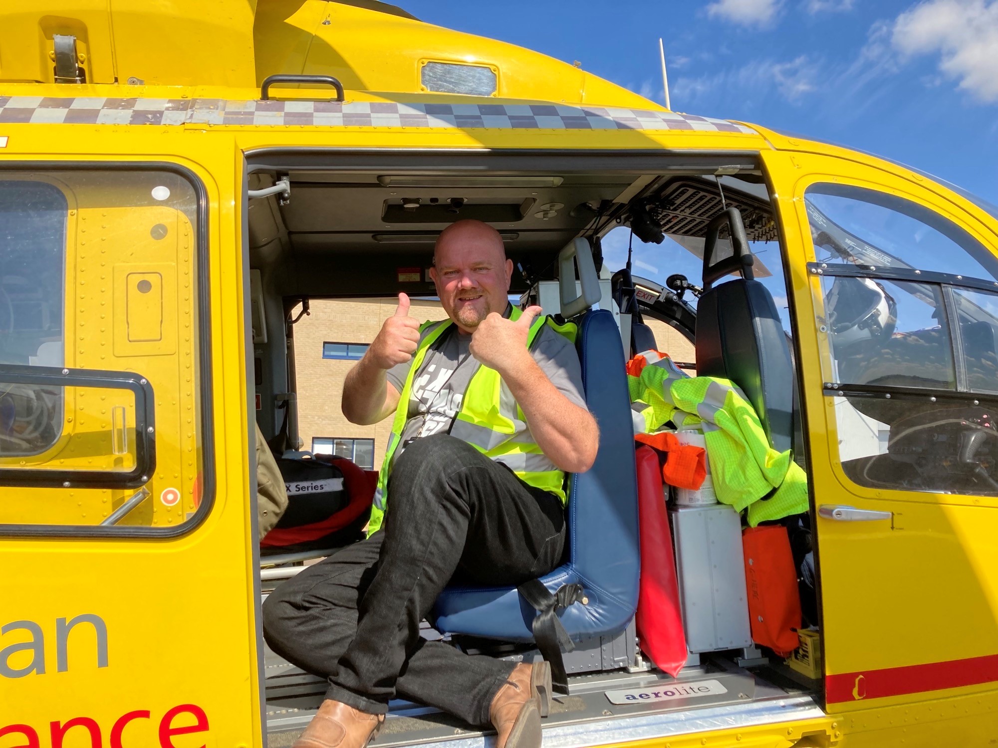 Keith inside the EAAA helicopter during a visit, giving a thumbs up.