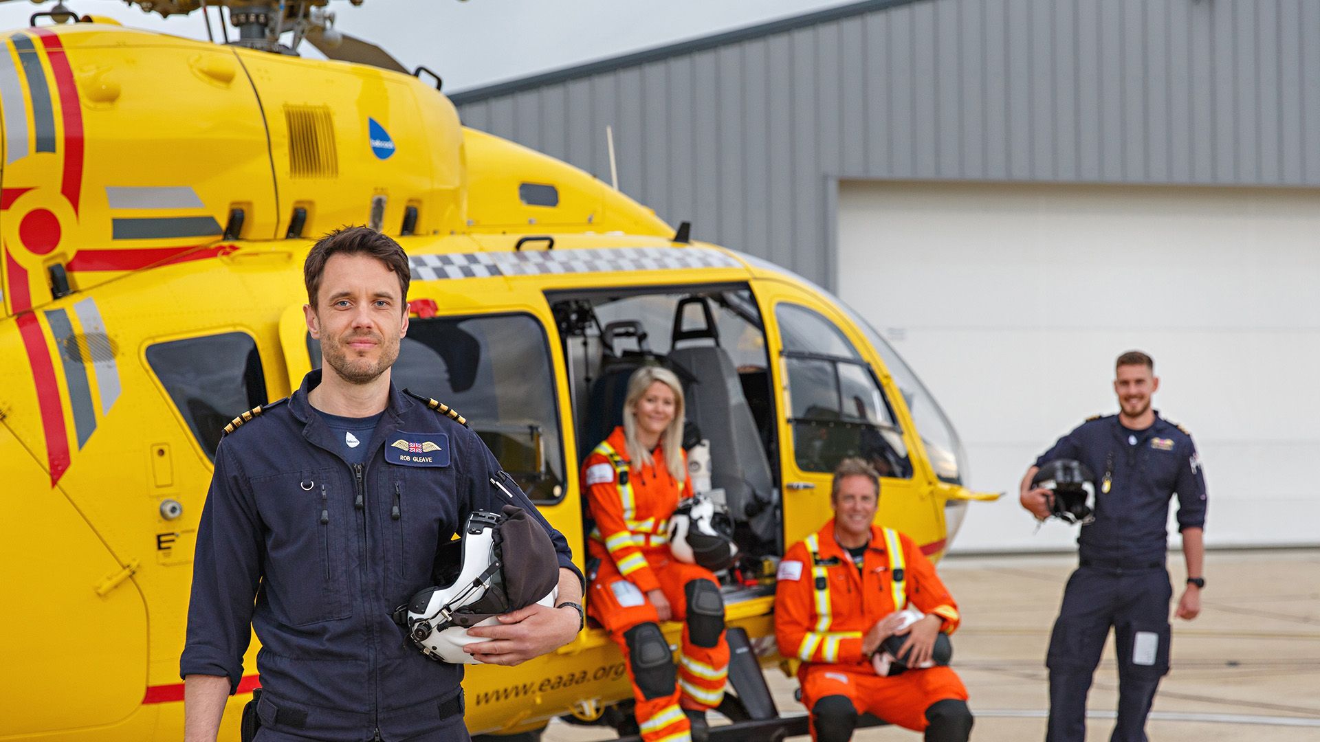 East Anglian Air Ambulance crew beside helicopter