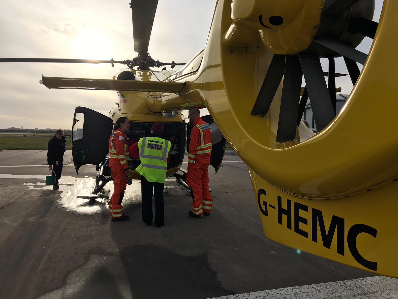 Sue Scarlett with EAAA clinicians looking inside the rear of EAAA's G-HEMC helicopter.