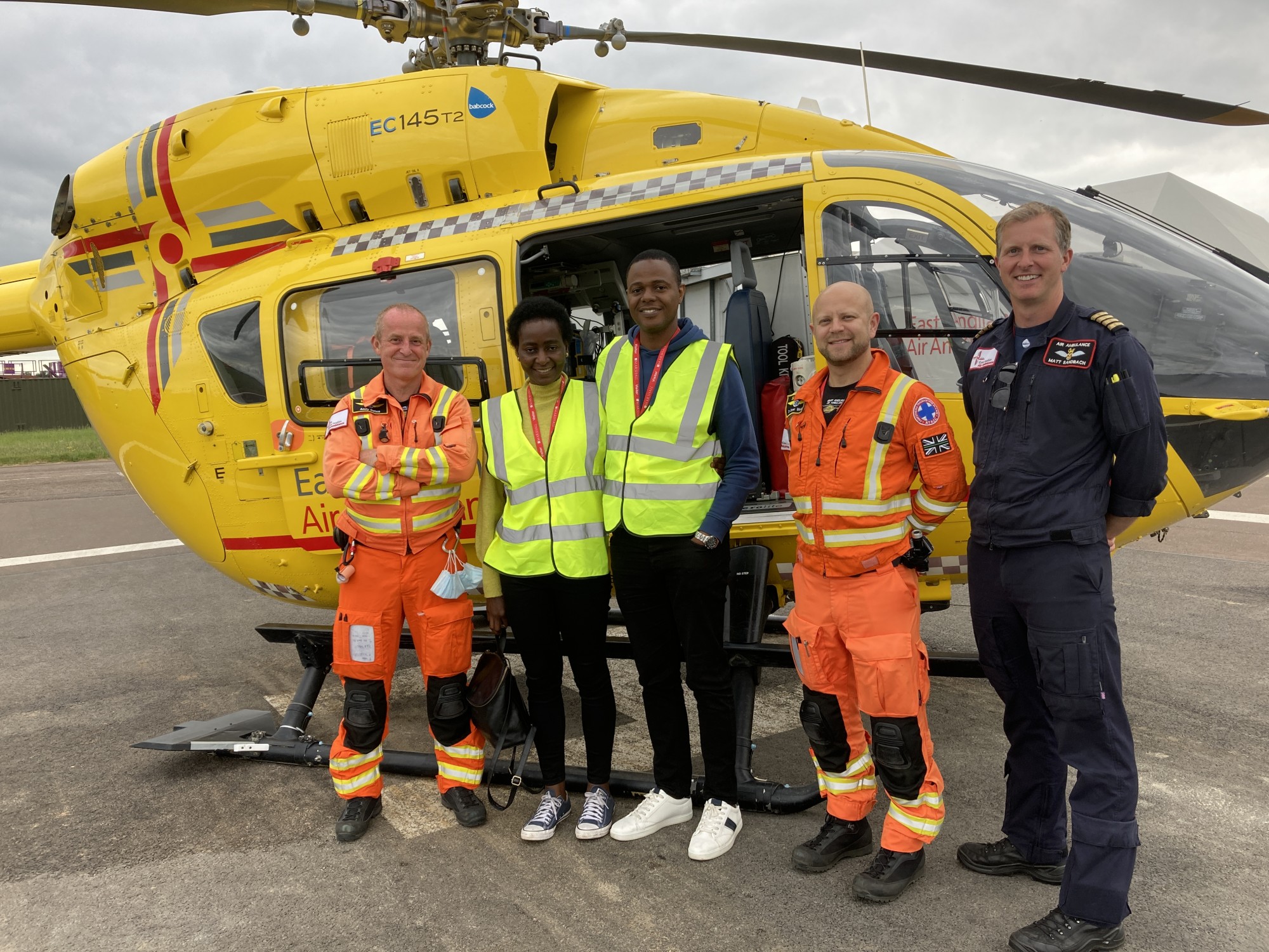 Tope with her husband and crew in front of the EAAA helicopter.