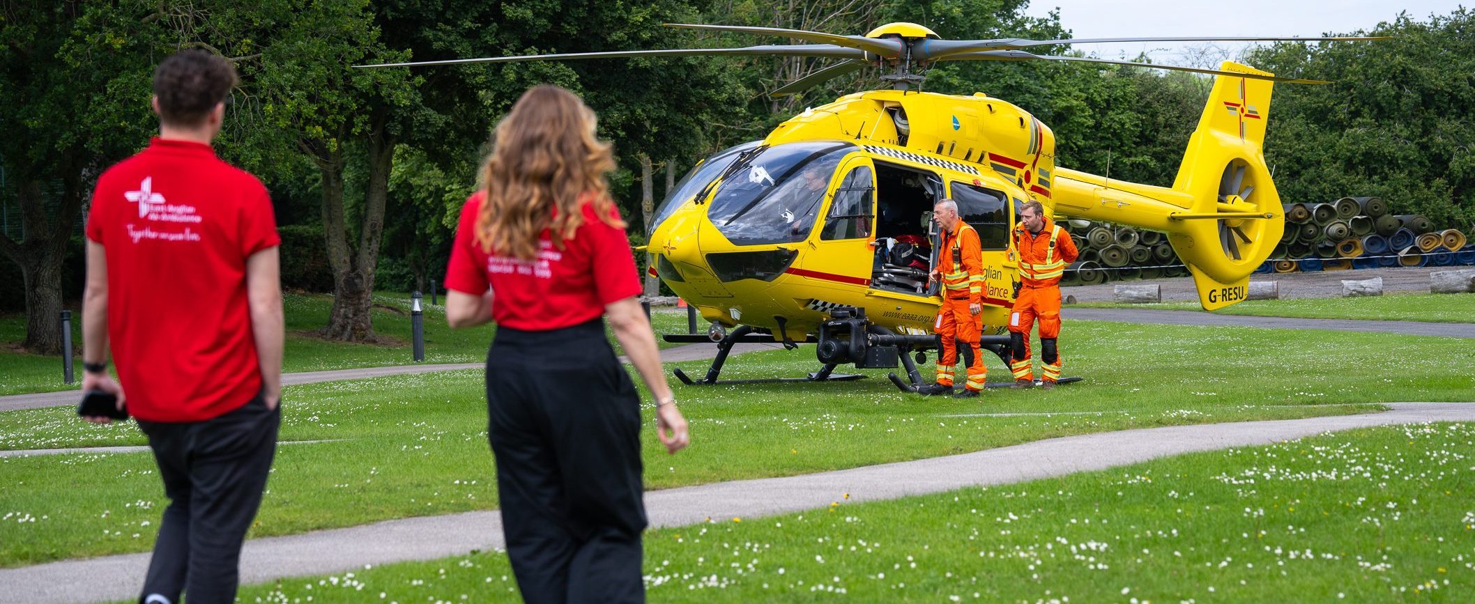 Two EAAA volunteers walking towards yellow helicopter