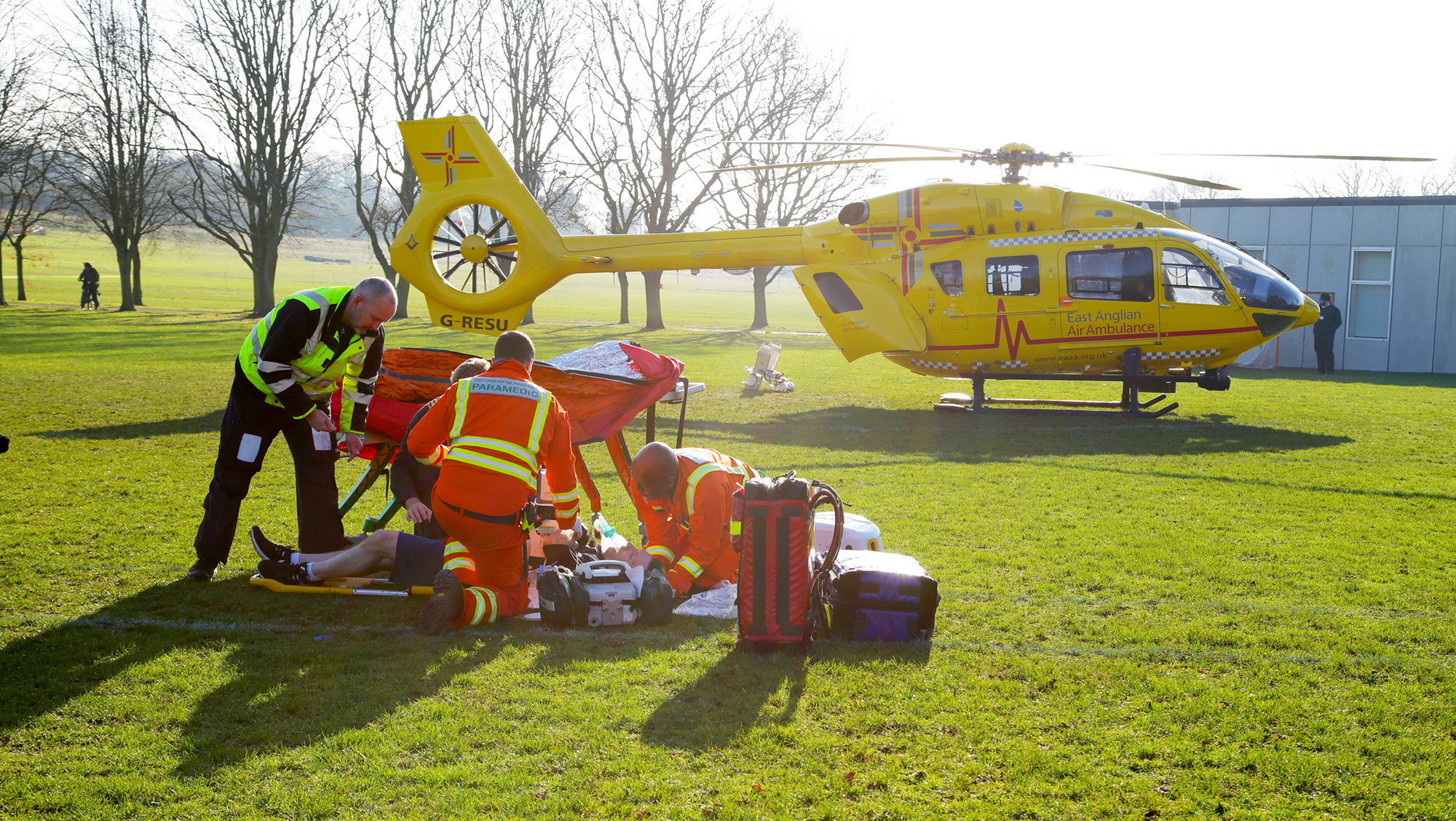 Doctor, paramedic and pilot with patient in a park