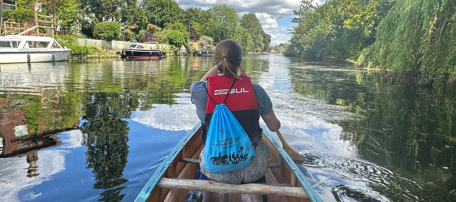 Women from behind rowing wearing a Together We Splash bag