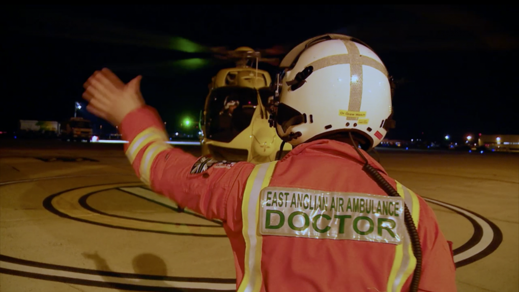 Doctor approaches helicopter at night